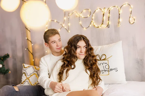 Young Beautiful Couple Sitting Bed Background Christmas Tree Smiling — Φωτογραφία Αρχείου