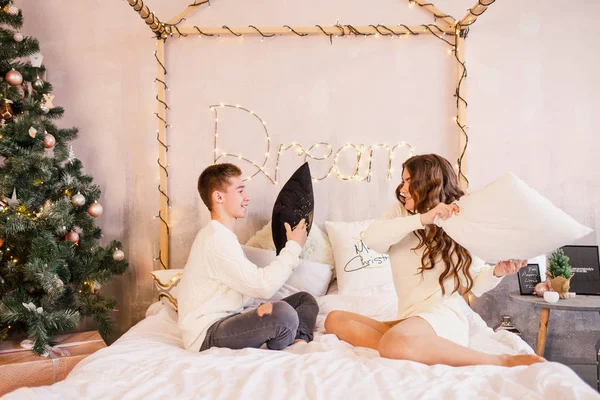 Young Beautiful Couple Sitting Bed Background Christmas Tree Smiling — Φωτογραφία Αρχείου