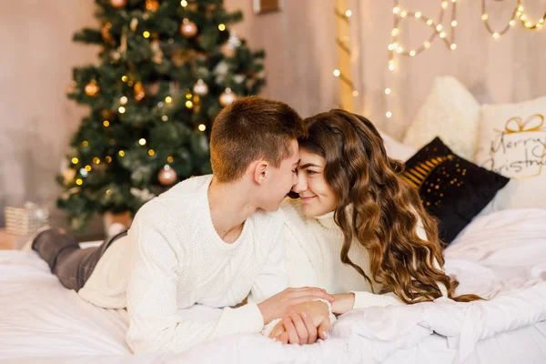 Jovem Casal Bonito Estão Sentados Cama Fundo Árvore Natal Sorrindo — Fotografia de Stock