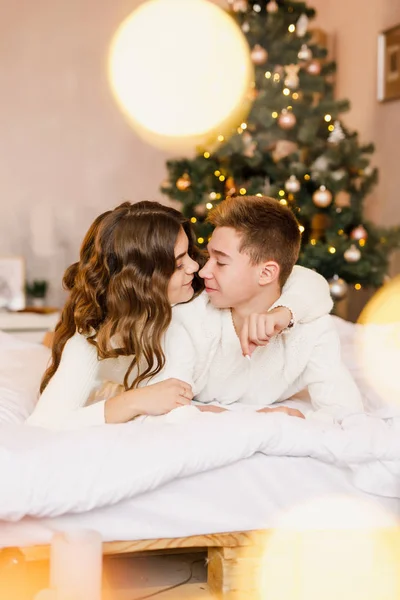 Jovem Casal Bonito Estão Sentados Cama Fundo Árvore Natal Sorrindo — Fotografia de Stock