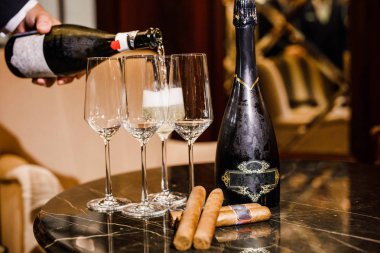 şarap ve Küba purosu masaya vardır