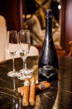 şarap ve Küba purosu masaya vardır