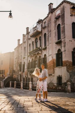 Genç güzel kız beyaz gömlek yürüyüş Venedik İtalya sokaklarında elbise erkek çift