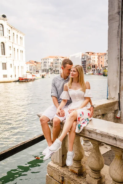 美しいカップル 白いドレスの女の子 青いシャツを着た男性はイタリアのヴェネツィアの美しい街でバルコニーに座っています — ストック写真