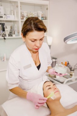 Güzel bir kadın güzellik salonunda genç bir kızın yüzünü alıyor..