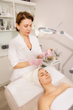 Kadın güzellik salonunda maske takıyor.