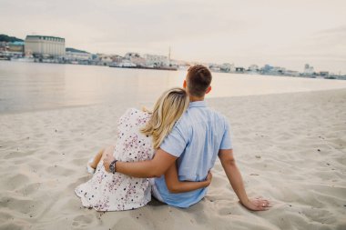 kum üzerine oturan ve sarılma poz Çift