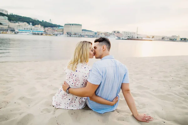 一对夫妇摆姿势坐在沙滩上接吻 — 图库照片