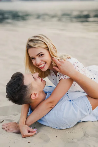 若いカップルが砂の上に横たわってポーズ — ストック写真