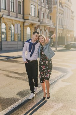 Işıklı cadde üzerinde yürüyen genç mutlu çift güneş