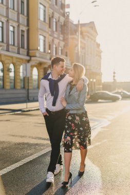 Işıklı cadde üzerinde yürüyen genç mutlu çift güneş