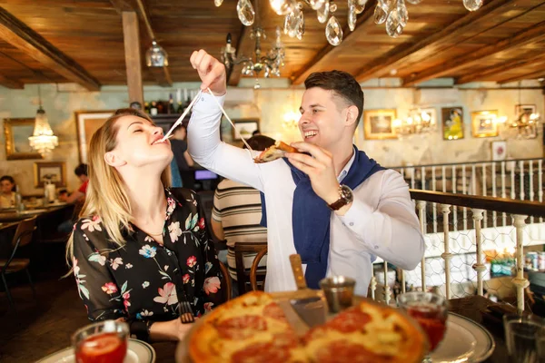 レストランのピザを食べて美しいカップル — ストック写真