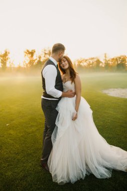Düğün çifti çimenlerde yürüyor.