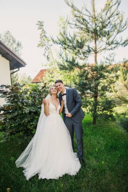 genç güzel çift gelin ve damat, gün batımı ve gülümseyerek gelin damat elbise şık giyimli güzel parkta yürüyüş