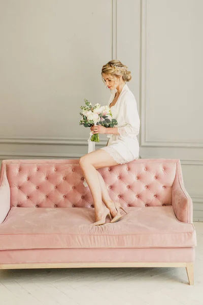 年轻美丽的新娘新娘坐在一张粉红色的床上 在明亮的房间里 面带微笑 — 图库照片