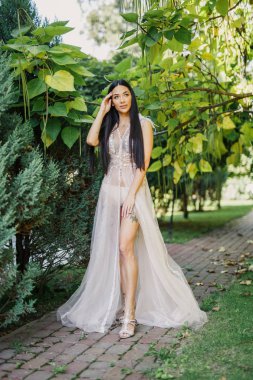 genç güzel gelinim parkta günbatımında duruyor.