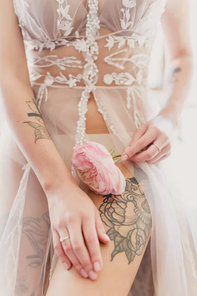 a beautiful tattoo on the leg of a girl she holds a flower in her hand