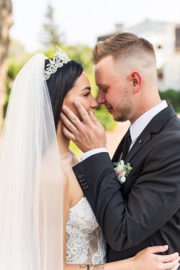 genç güzel düğün çift gelin ve damat parkta günbatımında ayaktadır ve gülümseyen güzel elbise damat gelini şık giyinmiş