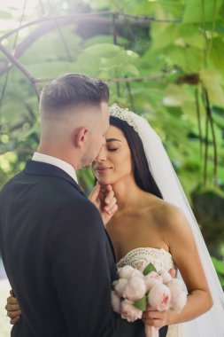 genç güzel düğün çift gelin ve damat parkta günbatımında ayaktadır ve gülümseyen güzel elbise damat gelini şık giyinmiş