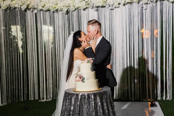 young beautiful wedding couple cuts the wedding cake and have fun