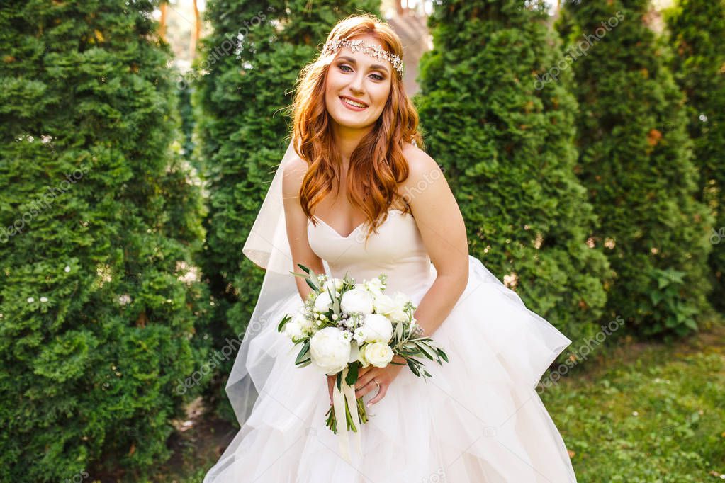 beautiful bride in white wedding dress posing outdoor