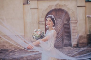 Beyaz gelinlikli güzel gelin kalenin çatısında poz veriyor.