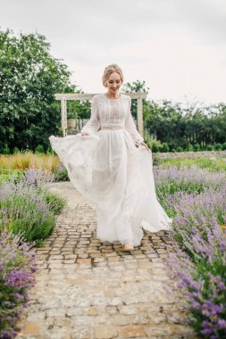 Parkta poz veren beyaz elbiseli güzel gelin