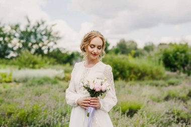 Parkta poz veren beyaz elbiseli güzel gelin