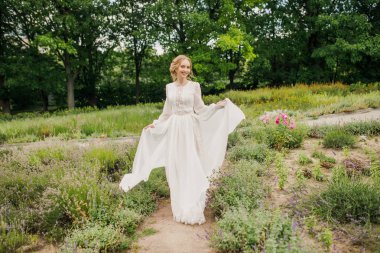 Parkta poz veren beyaz elbiseli güzel gelin