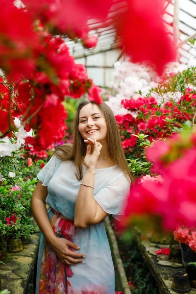 Elinde çiçekler olan kırmızı elbiseli güzel bir kadın.