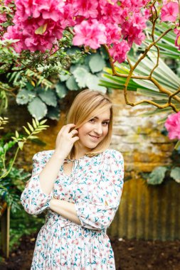 Bir yaz bahçesindeki güzel genç bir kadının portresi.