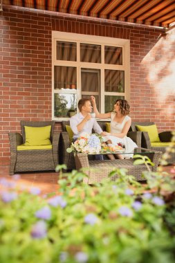 Çekici genç gelin ve damat kahve içip arka planda kafede oturuyorlar.