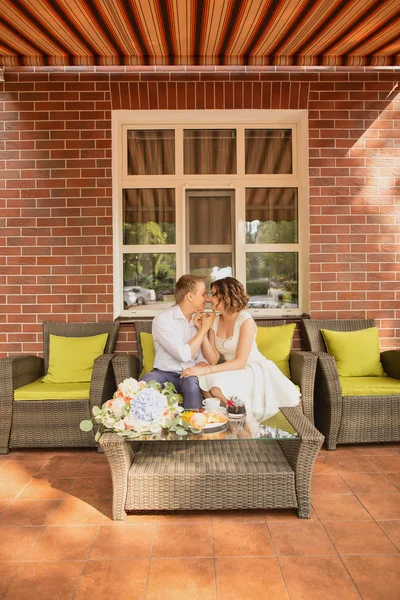 Çekici genç gelin ve damat kahve içip arka planda kafede oturuyorlar.