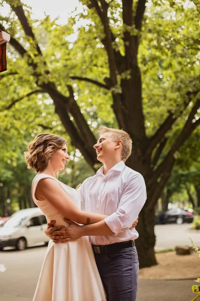 Çekici genç gelin ve damat arka planda kafenin yanında yürüyorlar.