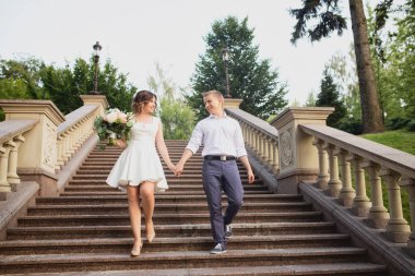 Genç gelin ve damat çimento mermer merdivenlerde poz veriyorlar.