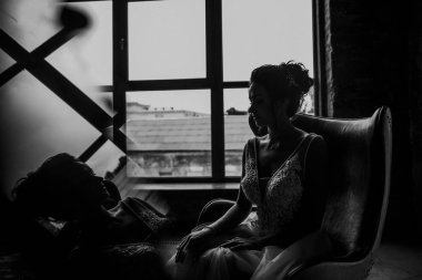 Gri bir arka planda güzel bir elbiseyle genç ve güzel bir gelinin portresi.