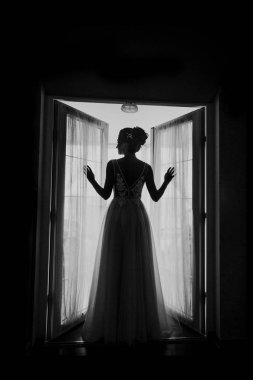 Gri bir arka planda güzel bir elbiseyle genç ve güzel bir gelinin portresi.