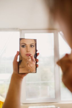 Gri bir arka planda güzel bir elbiseyle genç ve güzel bir gelinin portresi.