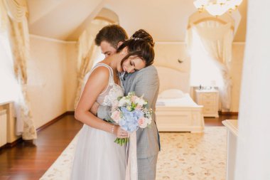 Genç ve güzel bir çift dairenin parlak bir odasında dikiliyorlar.