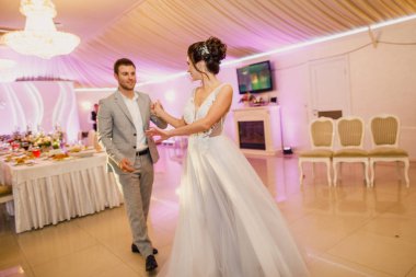Genç ve güzel bir çift bir restoranda dans ediyor ve güzel bir gelinlik içinde, şık bir şekilde giyinip, eğleniyorlar.