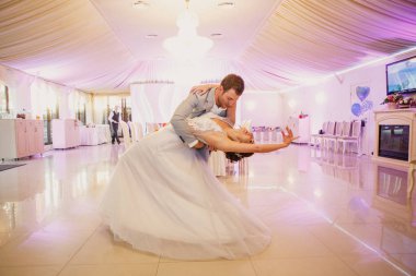 Genç ve güzel bir çift bir restoranda dans ediyor ve güzel bir gelinlik içinde, şık bir şekilde giyinip, eğleniyorlar.