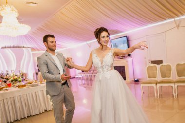 Genç ve güzel bir çift bir restoranda dans ediyor ve güzel bir gelinlik içinde, şık bir şekilde giyinip, eğleniyorlar.