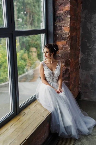 穿着灰色背景的漂亮时髦婚纱的年轻漂亮新娘的肖像 — 图库照片