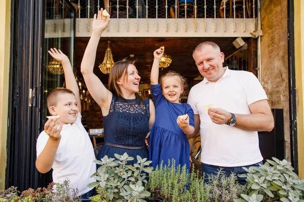 Genç aile babası anne ve kızı restoranda lezzetli pizzalar yiyorlar.