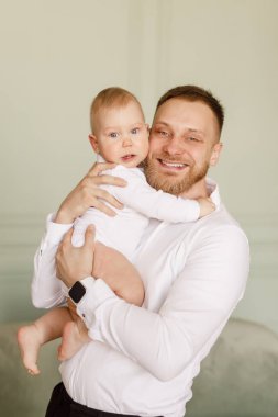 parlak dairede bir bebek tutan beyaz gömlekli genç adam