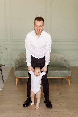 parlak dairede bir bebek tutan beyaz gömlekli genç adam