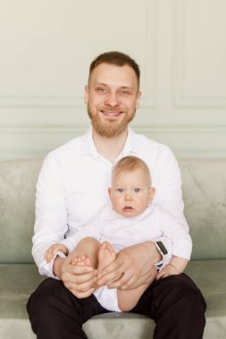 parlak dairede bir bebek tutan beyaz gömlekli genç adam