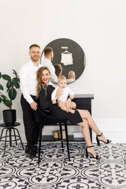 genç güzel aile şık parlak bir dairede ayakta giyinmiş