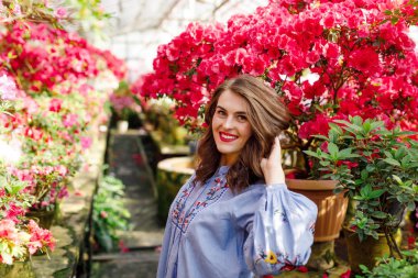 çiçekleri ile güzel bir botanik bahçesinde mavi bir elbise genç güzel bir kadının portresi