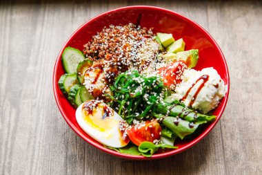 lezzetli ve iştah açıcı salata yumurta, domates, ıspanak, salatalık, peynir, kişniş, bir restoranda kırmızı bir tabak üzerinde yatıyor